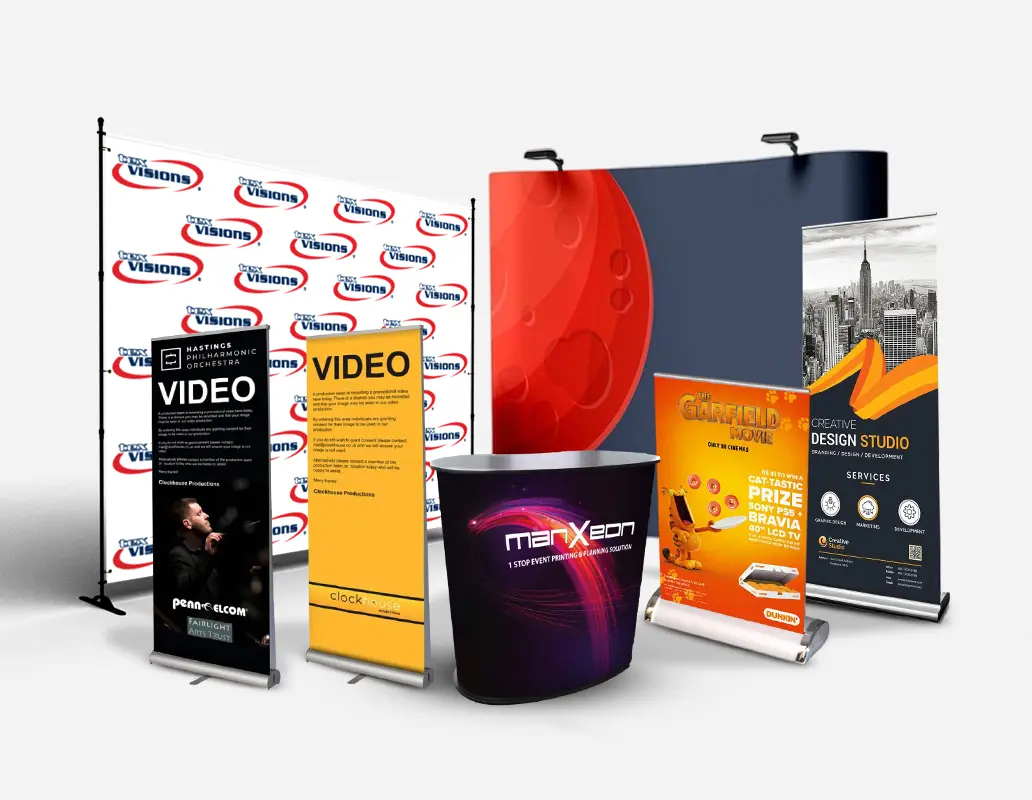 Trade show displays with backdrops, banners, and a promo counter featuring various brands, services, and event ads